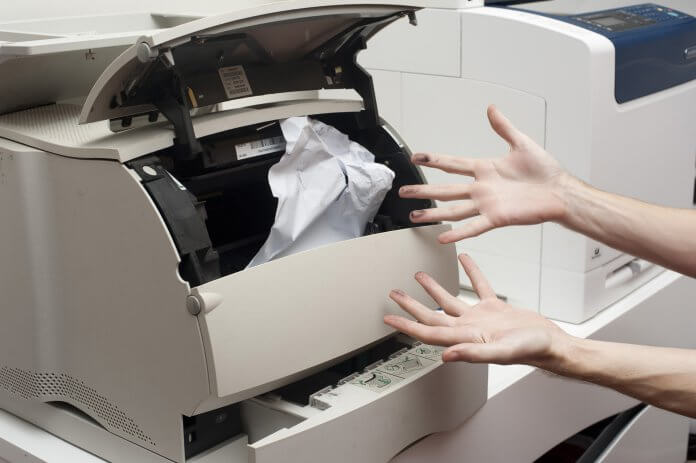 Frustrated person clearing paper jam
