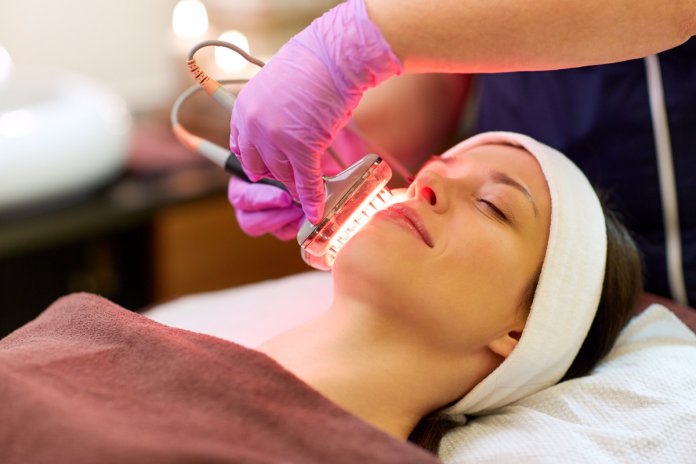 young woman having face microdermabrasion at spa