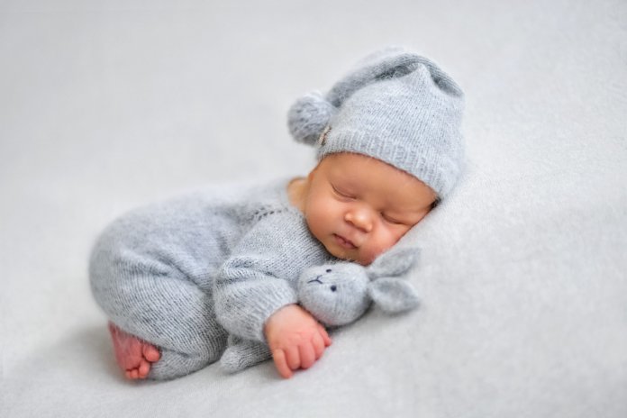 Sleeping newborn boy in the first days of life on white background