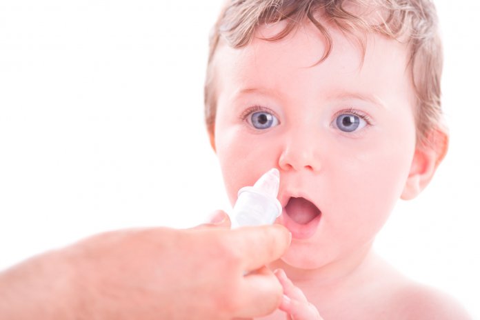 Mother using baby nasal aspirator.
