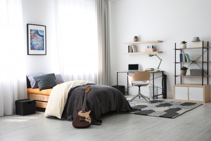 Modern teenager's room interior with workplace and bed